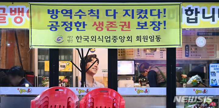 [수원=뉴시스] 김종택기자 = 정부의 코로나19 방역 지침 강화에 반발해 자영업자들의 집단행동이 잇따르고 있는 27일 오후 경기도 수원시 영통중심상가 한 음식점에 생존권 보장을 요구하는 현수막이 붙어있다. 2021.12.27.jtk@newsis.com