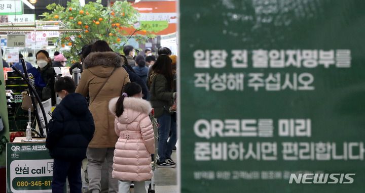 [서울=뉴시스] 추상철 기자 = 대형마트나 백화점 등 대규모 점포에 대한 방역패스(접종증명·음성확인제) 실시 의무화를 하루 앞둔  지난 9일 오후 서울 시내 한 대형마트에서 시민들이 QR코드로 출입인증을 위해 줄 서 있다. 2022.01.09. scchoo@newsis.com