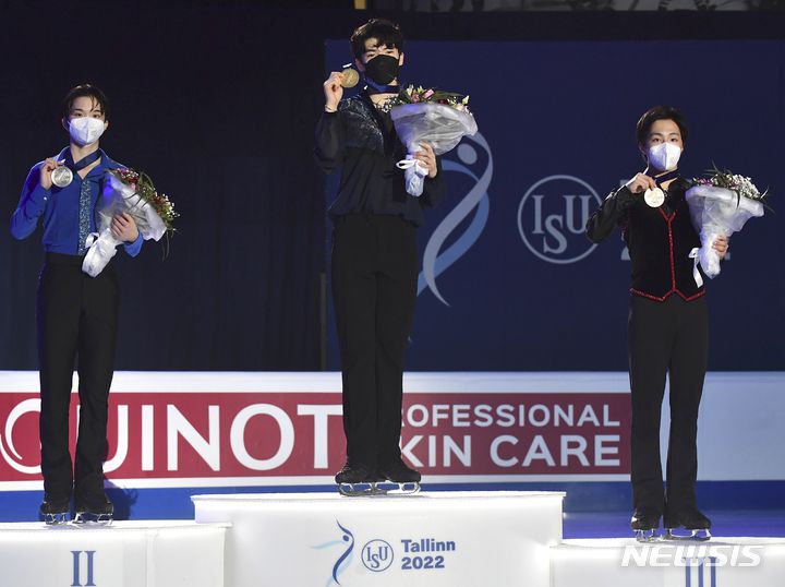 [탈린=AP/뉴시스] 차준환(가운데)이 23일(현지시간) 에스토니아 탈린의 톤디라바 아이스 홀에서 열린 2022 국제빙상연맹(ISU) 4대륙선수권대회에서 우승한 후 시상대에 올라 금메달을 들고 포즈를 취하고 있다. 차준환은 남자 싱글 프리스케이팅에서 기술점수(TES) 86.48, 예술점수(PCS) 88.78로 174.26점을 받아 전날 쇼트 프로그램 98.96점과 합쳐 273.22점으로 우승해 한국 선수 사상 처음으로 4대륙 대회 메달을 따냈다. 2022.01.24.