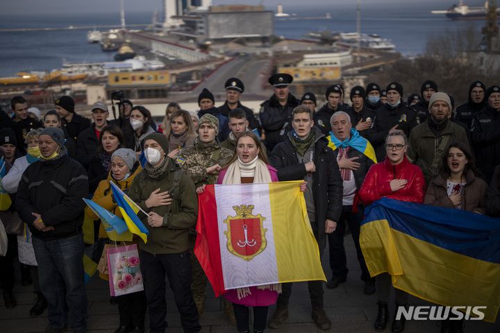 [오데사=AP/뉴시스] 16일(현지시간) 우크라이나 오데사 항구 앞에서 '단결의 날'을 기념하는 주민들이 국기를 들고 모여 국가를 부르고 있다. 볼로디미르 젤렌스키 우크라이나 대통령은 미국이 예상한 러시아 침공일인 16일을 '단결의 날'로 선포했다. 2022.02.17.