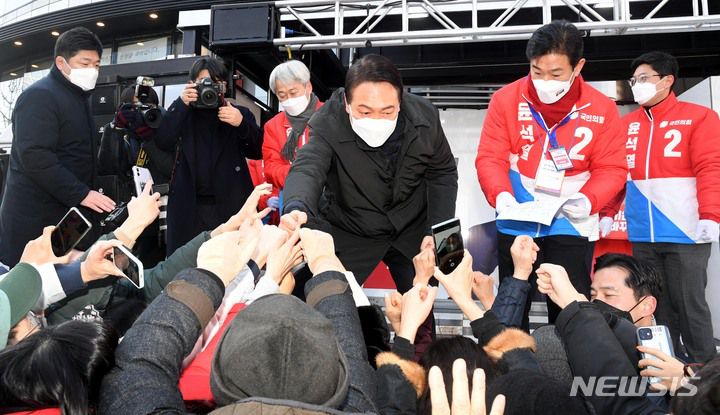 [서울=뉴시스] 국회사진기자단 = 윤석열 국민의힘 대선 후보가 17일 서울 송파구 석촌호수 서호 인근 사거리에서 유권자들을 향해 지지를 호소하고 있다. 2022.02.17. photo@newsis.com
