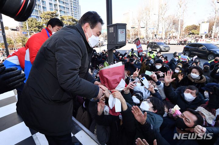 [서울=뉴시스] 국회사진기자단 = 윤석열 국민의힘 대선 후보가 17일 서울 송파구 석촌호수 서호 인근 사거리에서 유권자들을 향해 지지를 호소하고 있다. 2022.02.17. photo@newsis.com