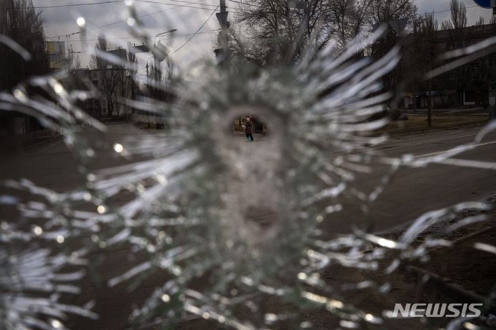 [키이우=AP/뉴시스]4일(현지시간) 우크라이나 수도 키이우에서 총탄에 깨진 버스 유리창 구멍으로 한 남성이 보인다. 2022.03.04.