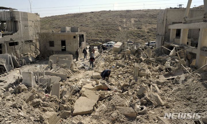 [다마스쿠스=AP/뉴시스]2022년 3월  시리아 다마스쿠스 인근에서 이스라엘의 공습 후 사람들이 피해 현황을 살펴보는 모습. 2023.02.19.