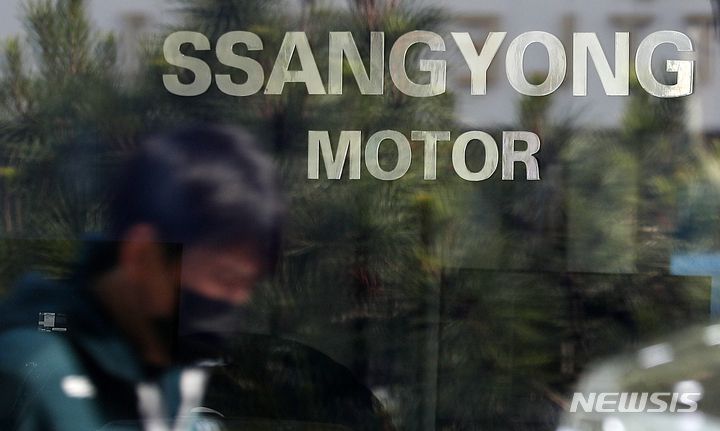 [서울=뉴시스] 백동현 기자 = 에디슨모터스의 쌍용차 인수계약이 무산될 위기에 놓인 27일 오전 서울 시내 한 쌍용차 판매점 앞에서 시민이 이동하고 있다. 이날 법조계에 따르면 에디슨모터스 컨소시엄은 인수대금 잔금 납입 기한인 지난 25일까지 잔금을 지급하지 못했다고 밝혔다. 2022.03.27. livertrent@newsis.com