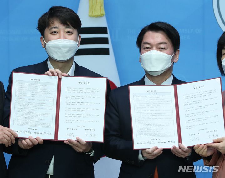 [서울=뉴시스] 전진환 = 이준석 국민의힘 대표와 안철수 국민의당 대표가 18일 서울 여의도 국회 소통관에서 기자회견을 열고 합당을 선언한 뒤 합의문을 들어보이고 있다. 2022.04.18.  photo@newsis.com
