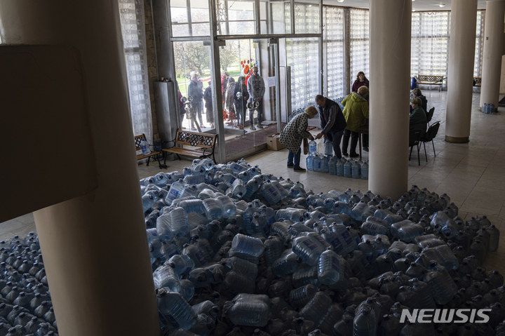 [토레츠크=AP/뉴시스] 지난 25일(현지시간) 우크라이나 동부 도네츠크주 토레츠크의 식수배급소에서 주민들이 식수를 배급받고 있다. 2022.04.27.