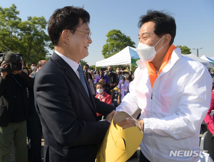 [서울=뉴시스] 김선웅 기자 = 오세훈 국민의힘 서울시장 후보와 송영길 더불어민주당 서울시장 후보가 15일 오후 서울 여의도한강공원에서 열린 서울특별시학원연합회 2022 학교폭력예방 캠페인에 참석해 인사를 나누고 있다. (공동취재사진) 2022.05.15. photo@newsis.com