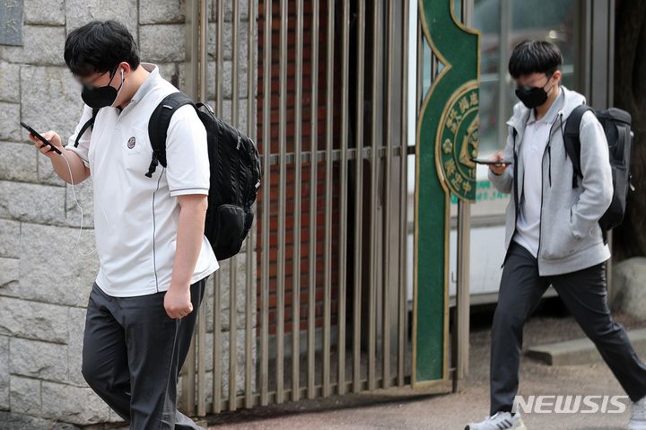 [서울=뉴시스] 백동현 기자 = 25일 오후 서울 시내 한 중학교 앞에서 학생들이 스마트폰을 보면서 하교하고 있다. 2022.05.25. livertrent@newsis.com **기사 내용과 관련 없습니다**