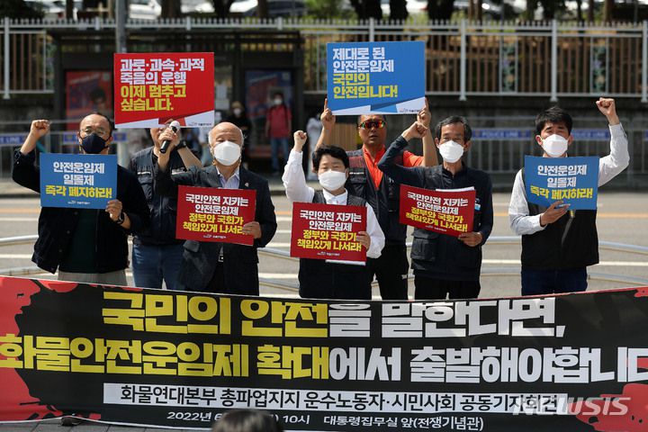 [서울=뉴시스] 백동현 기자 = 민주노총 공공운수노조 화물연대본부 조합원들이 2일 오전 서울 용산구 대통령집무실 앞에서 화물연대본부 총파업 지지 운수노동자·시민사회 공동기자회견을 열고 화물안전운임제 확대를 촉구하며 구호를 외치고 있다. 2022.06.02. livertrent@newsis.com