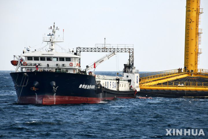 [칭다오=신화/뉴시스] 2022년 6월 18일 공개된 항공 사진에 앞선 7일 중국 산둥성 칭다오 앞바다의 어류 양식 실험 구역에서 연어 가공선 한 척이 대서양 연어를 수확하기 위해 '선란 1호(Deep Blue No.1)'에 접근하고 있다. '선란 1호'는 중국 서해 해안선에서 약 130해리(약 240km) 떨어진 해역에 있으며 중국이 건조한 최초의 완전 잠수형 심해 어류 양식 장비다. 5월 22일부터 6월 9일까지 이 장비를 통해 약 1만5천 마리의 대서양 연어가 어획됐으며, 이는 중국이 자가 번식한 심해산 대서양 연어의 첫 수확 사례로 기록됐다. 2025.06.11.
