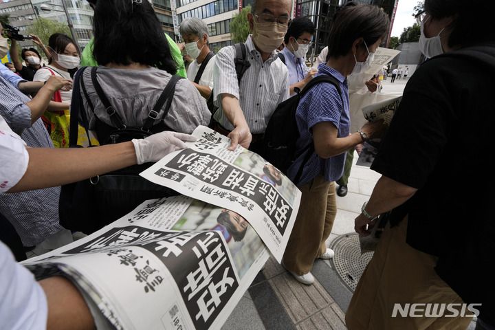 [도쿄=AP/뉴시스] 8일 일본 도쿄에서 요미우리 신문사 직원들이 아베 신조 전 총리의 피격 소식을 전하는 호외판을 배포하고 있다. 2022.07.08.