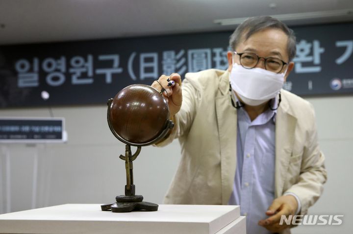 [서울=뉴시스] 고승민 기자 = 이용삼 충북대 명예교수가 18일 서울 국립고궁박물관에서 문화재청이 지난 3월 미국 경매를 통해 매입해 공개한  '일영원구'를 설명하고 있다. 지금까지 학계에 알려진 바 없는 희귀 유물인 '일영원구'는 국내 최초 확인된 구형 휴대용 해시계다. 두 개의 반구가 맞물린 원구 형태로 각종 장치를 조정해 어느 지역에서나 시간을 측정할 수 있게 제작된 것이 특징이다. 2022.08.18. kkssmm99@newsis.com