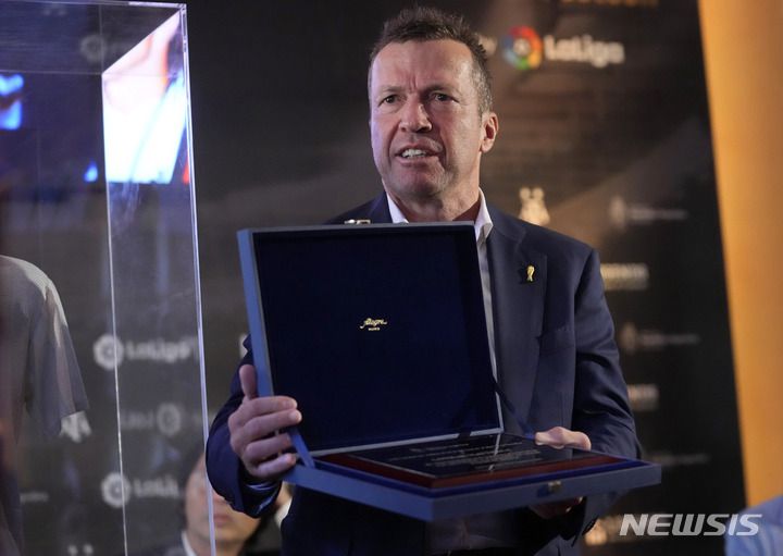 [마드리드=AP/뉴시스] 로타어 마테우스가 26일(한국시간) 스페인 마드리드의 아르헨티나 대사관에서 디에고 마라도나가 1986년 FIFA 멕시코 월드컵 결승전 당시 입었던 유니폼을 기증한 뒤 아르헨티나 대사관에서 수여한 상을 받고 있다. 2022.08.26.