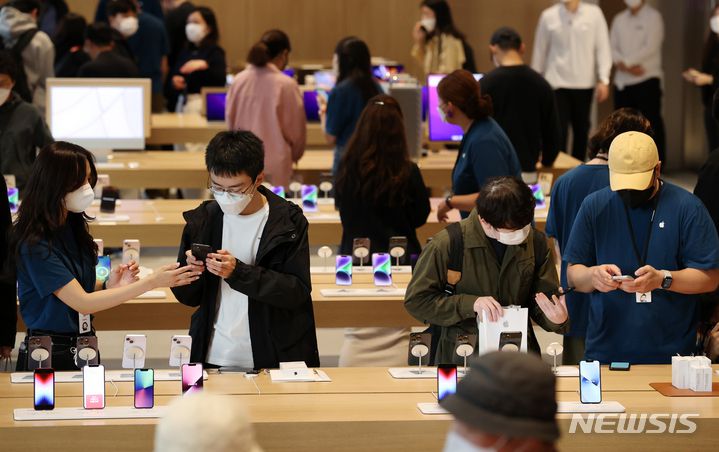 [서울=뉴시스] 조성우 기자 = 애플의 신작 아이폰14 시리즈 공식 출시일인 7일 오전 서울 중구 명동 애플스토어에서 고객들이 직원들의 설명을 들으며 아이폰14 시리즈를 살펴보고 있다. 2022.10.07. xconfind@newsis.com