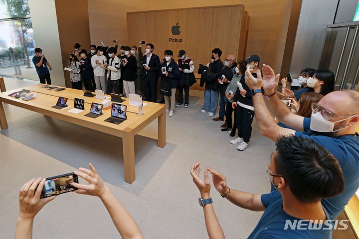 [서울=뉴시스] 조성우 기자 = 애플의 신작 아이폰14 시리즈 공식 출시일인 7일 오전 서울 중구 명동 애플스토어에서 직원들이 첫 구매 고객들에게 박수를 보내고 있다. 2022.10.07. xconfind@newsis.com