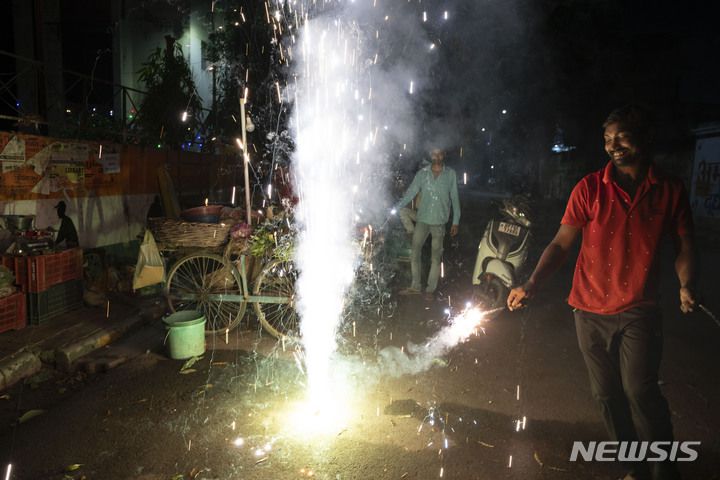 [인도=AP/뉴시스] 시민들이 24일(현지시간) 인도에서 열린 힌두교 최대 축제인 디왈리를 기념해 폭죽을 터뜨리고 있다. 2022.10.25.