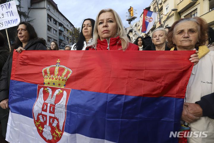 [코소브스카 미트로비차=AP/뉴시스] 2022년 11월 23일(현지시간) 코소보 북부 코소프스카 미트로비차에서 세르비아 국기를 든 여성들이 행진하고 있다.  코소보 독립을 인정하지 않는 북부 세르비아계 주민들은 대부분 세르비아 정부가 발급한 차량 번호판을 사용하고 있어 차량 번호판 교체 압박에 강력히 반발하고 있다. 2023.05.30