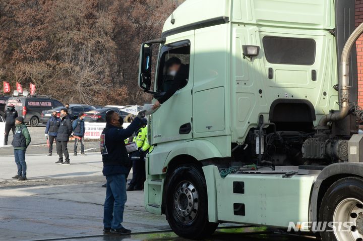 [단양=뉴시스] 조성현 기자 = 민주노총 화물연대 파업 14일째인 7일 오후 충북 단양군 성신양회 단양공장 앞에서 화물연대 조합원들이 비조합원에게 유인물을 나눠주고 있다. 2022.12.07. jsh0128@newsis.com