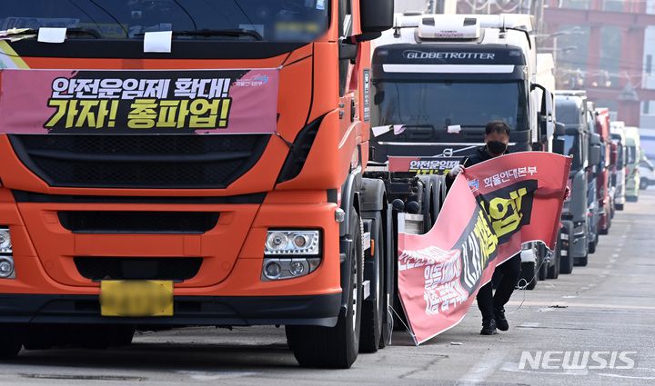 [의왕=뉴시스] 김종택 기자 = 화물연대가 총파업을 철회한 9일 오후 경기도 의왕시 내륙컨테이너기지(ICD)앞 도로에 주차된 화물차에서 한 조합원이 현수막을 철거하고 있다. 2022.12.09. jtk@newsis.com