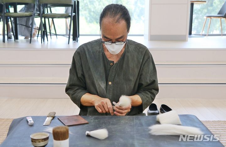 [증평=뉴시스] 강신욱 기자 = 충북 증평군 도안면 화성3리가 농림축산식품부의 2023년 농촌축제 지원사업 공모에 선정돼 내년에 '붓마을 작다리축제'를 연다. 사진은 이 마을에 작업장을 둔 충북도 무형문화재 유필무 필장이 지난 7월2일 독서왕김득신문학관에서 열린 충북도 무형문화재 공개행사에서 붓털 제작을 시연하고 있다. 2022.12.16. ksw64@newsis.com