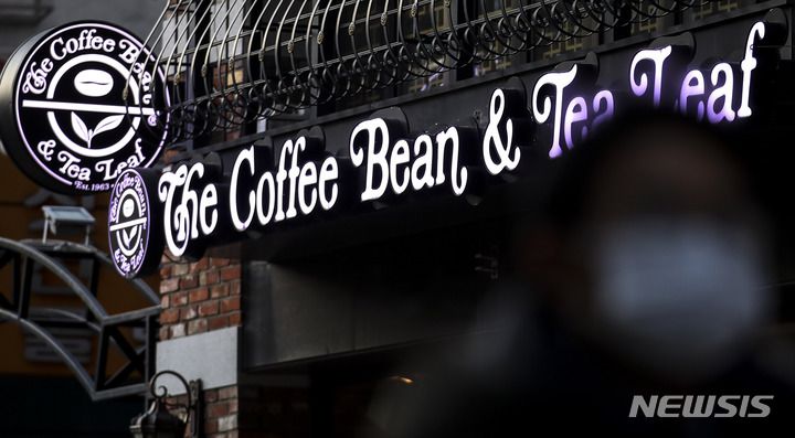 [서울=뉴시스] 정병혁 기자 = 2일 오전 서울시내 커피빈 앞에서 시민들이 이동하고 있다. 커피 전문점 '커피빈'은 3일부터 우유가 포함된 음료의 가격을 200원씩 올린다. 소비자들은 카페라떼(s)를 기존 5600원에서 5800원에, 바닐라라떼(s)는 6100원에서 6300원에 구매할 수 있다. 2023.01.02. jhope@newsis.com