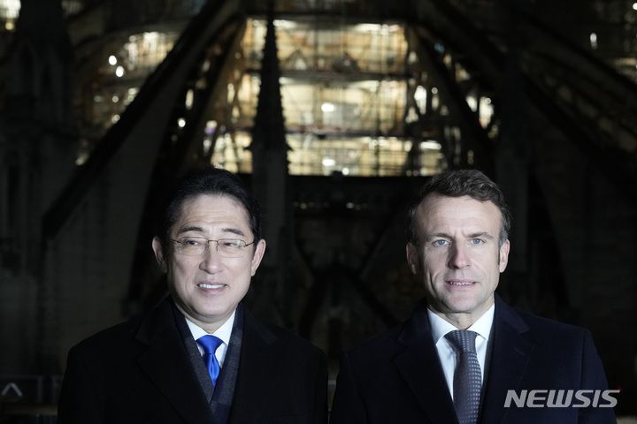 [파리=AP/뉴시스] 프랑스를 방문한 기시다 후미오(왼쪽) 일본 총리가 9일(현지시간) 에마뉘엘 마크롱 프랑스 대통령과 함께 파리의 노트르담 대성당 재건 현장을 방문해 둘러보고 있다. 기시다 총리는 5월 일본에서 열리는 주요 7개국(G7) 정상회의를 앞두고 회원국을 순방 중이다. 2023.01.10.