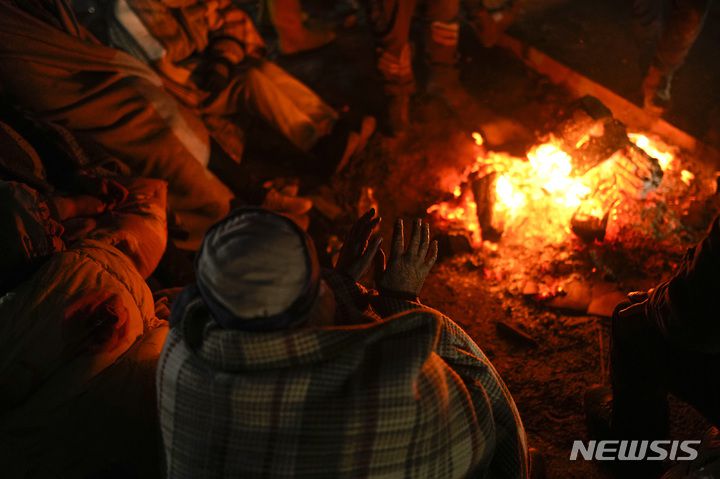 [엘비스탄=AP/뉴시스] 8일(현지시간) 튀르키예 엘비스탄에서 한 가족이 가 지진으로 파괴된 집 앞에 피운 모닥불로 몸을 녹이고 있다. 튀르키예와 시리아를 강타한 지진으로 사망자 숫자가  1만2천 명을 넘은 것으로 나타났으며 생존자를 구할 수 있는 골든 타임이 얼마 남지 않은 상황에서 강추위로 어려움이 가중되고 있다. 2023.02.09.