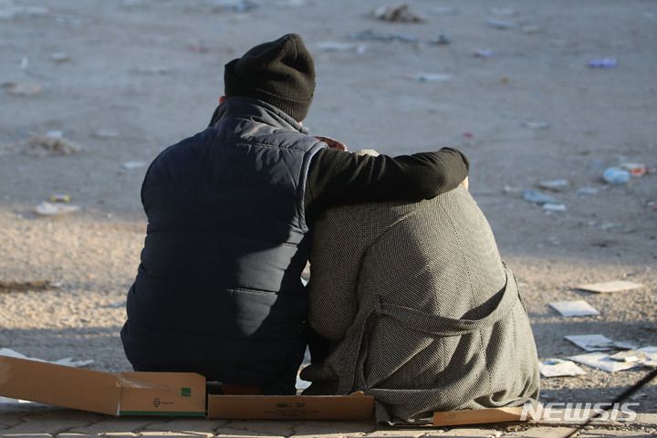 [카라만마라슈=뉴시스] 권창회 기자 = 12일 오후(현지시간) 튀르키예 카라만마라슈주 시내 지진피해 현장에서 한 부부가 슬픔에 빠져 있다. 2023.02.13. kch0523@newsis.com