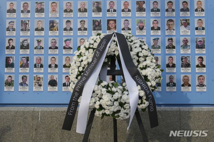 [키이우=AP/뉴시스] 21일(현지시간) 우크라이나 키이우에 있는 러시아-우크라이나 전쟁 전사자 추모의 벽에 기시다 후미오 일본 총리가 헌화한 화환이 놓여 있다. 2023.03.22.