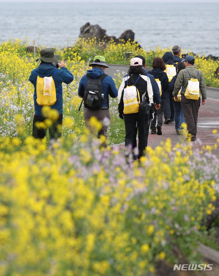 [서귀포=뉴시스] 우장호 기자 = 제25회 서귀포유채꽃 국제걷기대회가 열린 25일 오전 참가자들이 제주 서귀포시 법환해안도로를 걸으며 봄 정취를 만끽하고 있다. 2023.03.25. woo1223@newsis.com