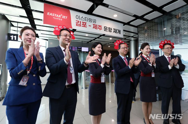 [서울=뉴시스] 최동준 기자 = 조중석 이스타항공 대표(오른쪽)과 유상종 경영총괄 전무, 이경민 커머셜본부장 및 승무원들이 26일 오전 김포국제공항 국내선 탑승 게이트에서 승객들에게 감사의 박수를 보내고 있다. 이스타 항공은 오늘부터 김포-제주 노선을 시작으로 3년 만에 운항을 재개했다. (공동취재사진) 2023.03.26. photo@newsis.com