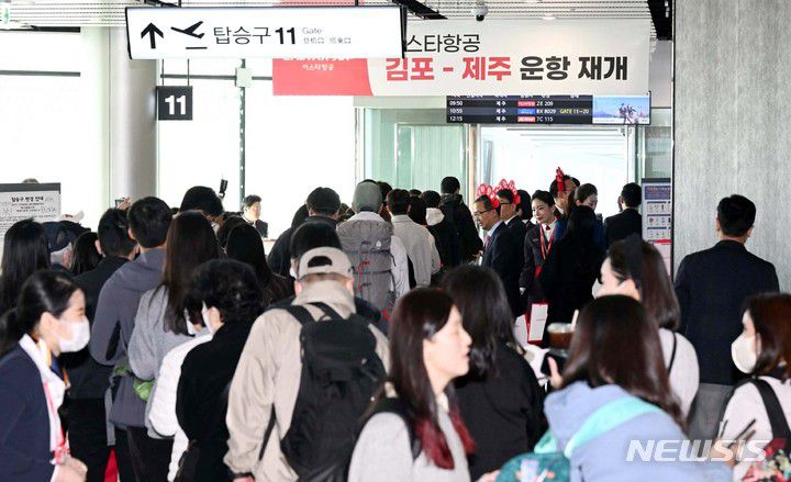 [서울=뉴시스] 최동준 기자 = 26일 김포공항 국내선 탑승동 게이트에서 이스타항공 승객들이 비행기 탑승을 위해 줄을 서 있다. 이날 이스타항공은 지난 2020년 3월 24일 경영난으로 운항을 중단한 후 3년 만에 운항을 재개했다. (공동취재사진) 2023.03.26. photo@newsis.com