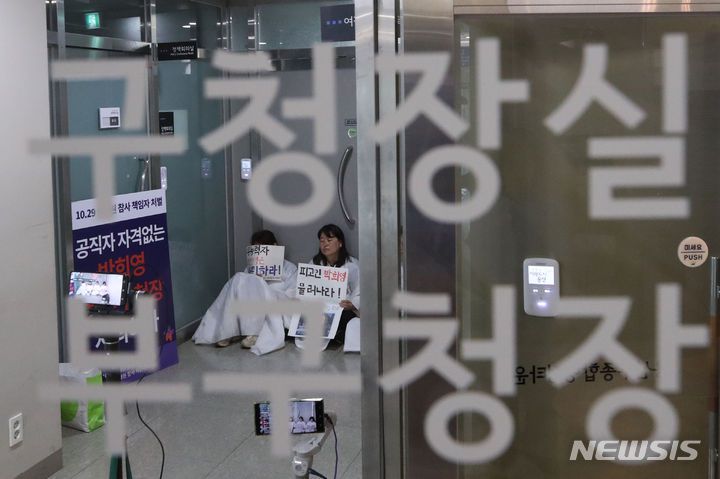 [서울=뉴시스] 권창회 기자 = 13일 오전 서울 용산구 용산구청 구청장실 앞에서 소복을 입은 이태원 참사 유가족들이 박희영 용산구청장 사퇴 촉구 손피켓을 들고 있다. 2023.06.13. kch0523@newsis.com