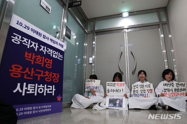 [서울=뉴시스] 권창회 기자 = 13일 오전 서울 용산구 용산구청 구청장실 앞에서 소복을 입은 이태원 참사 유가족들이 박희영 용산구청장 사퇴 촉구 손피켓을 들고 있다. 2023.06.13. kch0523@newsis.com