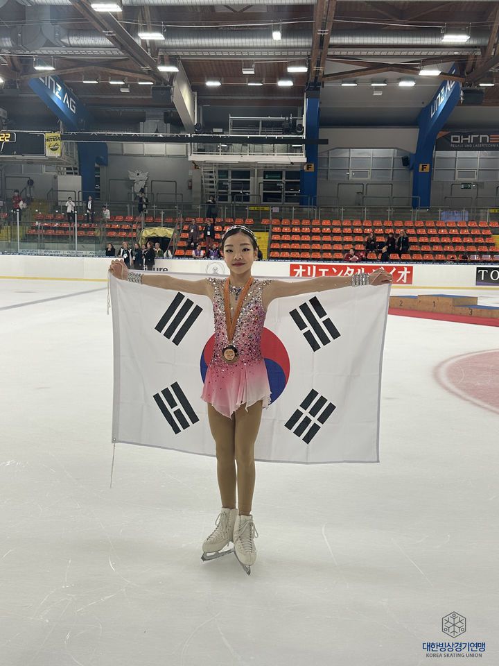 [서울=뉴시스] 김진아 기자 = 대한빙상경기연맹(회장 윤홍근ㆍ제너시스BBQ 그룹 회장)은 2023/24 시즌 ISU 피겨 주니어 그랑프리 시리즈 2차 대회 여자 싱글에서 신지아(영동중)와 권민솔(목동중)이 1위와 3위를 차지하며 함께 시상대에 오르는 쾌거를 거두었다고 밝혔다.  사진은 이날 메달을 목에 걸고 포즈를 취하는 권민솔. (사진=대한빙상경기연맹 제공) 2023.09.02. photo@newsis.com *재판매 및 DB 금지