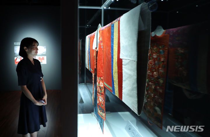 [서울=뉴시스] 최진석 기자 = 13일 서울 종로구 국립고궁박물관에서 열린 특별전시 ‘활옷만개-조선왕실 여성 혼례복’ 언론공개회에서 관계자가 그룹 '방탄소년단' 멤버 RM의 후원으로 복원된 조선시대 혼례복인 '활옷'을 살펴보고 있다. 이번 전시는 국립고궁박물관 2층 기획전시실에서 15일부터 12월 13일까지 진행된다. 2023.09.13. myjs@newsis.com