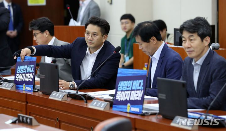 피켓 붙이는 더불어민주당 의원들.[서울=뉴시스] 이영환 기자 = 전용기 더불어민주당 의원이 13일 오후 서울 여의도 국회에서 열린 환경노동위원회 전체회의에서 노트북에 피켓을 붙이고 있다. 2023.09.13. 20hwan@newsis.com