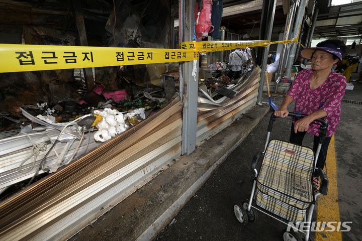 [광주=뉴시스] 이영주 기자 = 21일 오전 광주 광산구 비아5일장에서 한 손님이 전날 오후 불이 났던 상가를 바라보고 있다. 비아5일장에서는 지난 20일 오후 6시 58분께 불이 나 상가 10동(89.7㎡)이 타거나 그을리고 소방서 추산 1900만원 상당의 재산 피해가 났다. 2023.09.21. leeyj2578@newsis.com