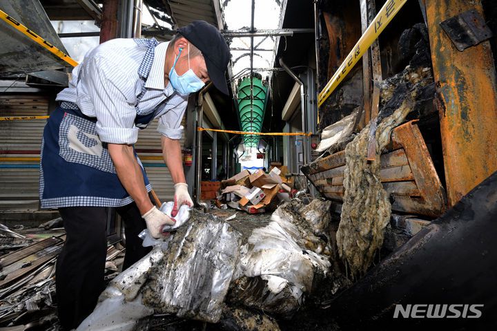 [광주=뉴시스] 이영주 기자 = 21일 오전 광주 광산구 비아5일장에서 전날 오후 발생한 상가 화재 피해를 겪은 상인이 불탄 잔해를 정리하고 있다. 비아5일장에서는 지난 20일 오후 6시 58분께 불이 나 상가 10동(89.7㎡)이 타거나 그을려 소방서 추산 1900만원 상당의 재산 피해가 났다. 2023.09.21. leeyj2578@newsis.com