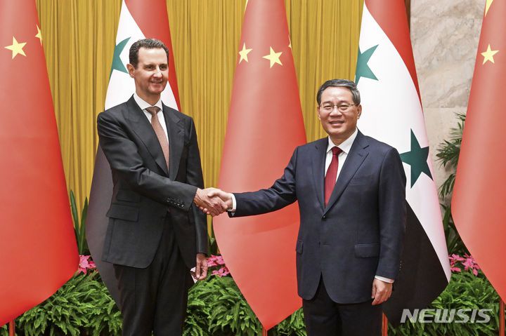 [베이징=AP/뉴시스] 리창 중국 총리가 2023년 9월 25일 중국 베이징에서 바샤르 알아사드 시리아 대통령과 회담에 앞서 악수하고 있다. 아사드 대통령은 항저우에서 열린 제19회 아시안게임 개막식에 참석한 뒤 베이징을 방문했다. 2025.12.16.