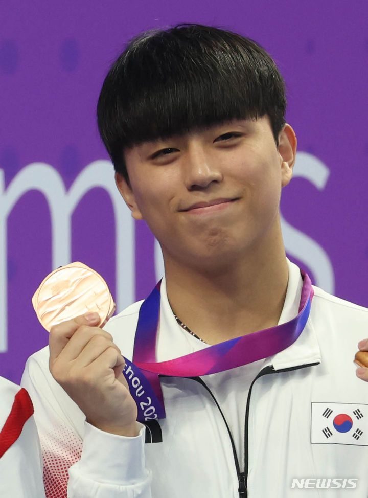 [항저우=뉴시스] 조수정 기자 = 3일 중국 항저우 올림픽스포츠센터 아쿠아틱스포츠아레나에서 열린 2022 항저우 아시안게임 다이빙 3m 스프링보드 남자 개인 동메달을 획득한 이재경이 시상식에서 메달을 들어보이고 있다. 2023.10.03. chocrystal@newsis.com