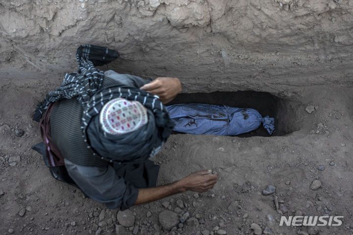 [제데흐잔=AP/뉴시스] 9일(현지시각) 아프가니스탄 헤라트주 제데흐잔에서 한 남성이 지진으로 숨진 손자를 매장하고 있다. 지난 7일 아프간에서 발생한 지진으로 지금까지 최소 2400명이 숨지고 2천 명이 다친 것으로 알려졌다. 2023.10.10.