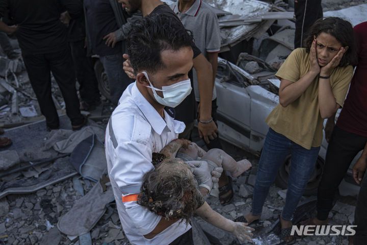 [칸유니스= AP/뉴시스] 가자지구의 이스라엘군 공습으로 폐허에 묻혔던  아기의 시신을 보고 놀라는 팔레스타인 소녀. 2023. 12.20.