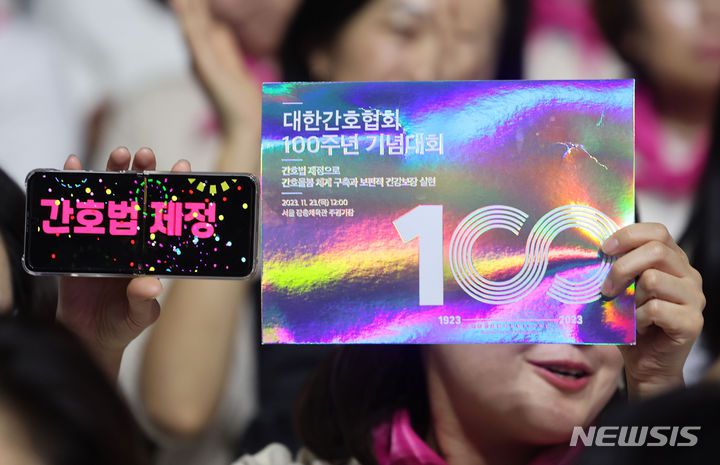 [서울=뉴시스] 지난 2023년 11월 23일 오후 서울 중구 장충체육관에서 열린 대한간호협회 100주년 기념대회에서 간호사가 피켓과 간호법 제정 문구를 들고 있는 모습. 2023.11.23. photo@newsis.com