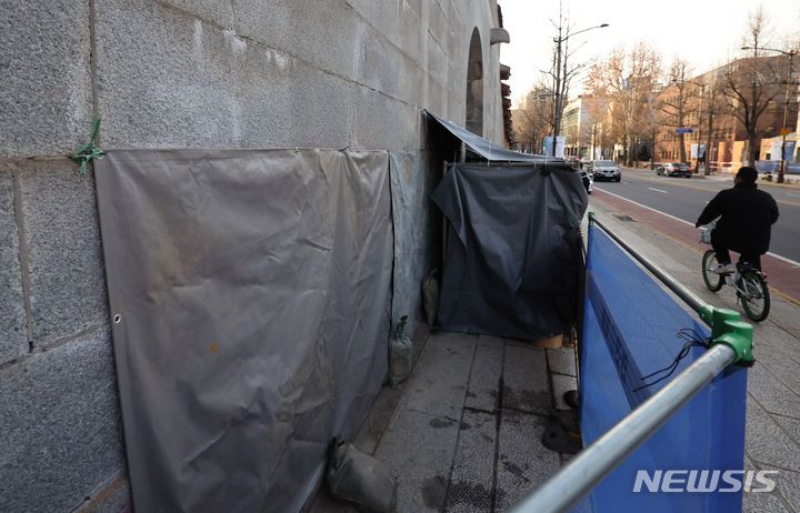 [서울=뉴시스] 김근수 기자 = 18일 서울 종로구 영추문 인근에서 스프레이 낙서로 훼손된 담벼락 앞으로 한 시민이 지나가고 있다. 2023.12.18. ks@newsis.com