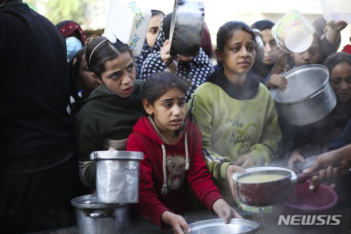 [라파=AP/뉴시스] 20일(현지시각) 가자지구 남부 라파의 급식소에 무료 음식을 받으려는 팔레스타인 어린이들이 몰려들어 음식을 받고 있다. 2023.12.21.