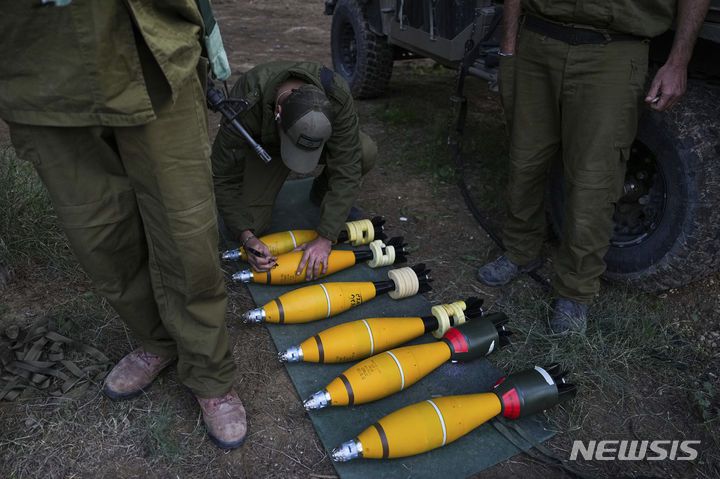 [가자지구=AP/뉴시스] 20일(현지시각) 이스라엘 남부, 가자지구 인근 진지에서 한 이스라엘 군인이 박격포탄에 무언가를 쓰고 있다. 2023.12.21.