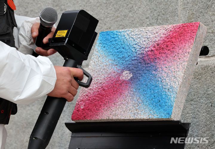 [서울=뉴시스] 조성우 기자 = 4일 오전 서울 종로구 경복궁 영추문에서 이태종 국립문화재연구원 학예연구사가 레이저 장비를 활용해 낙서 제거 작업을 시연하고 있다. 2024.01.04. xconfind@newsis.com