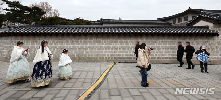 [서울=뉴시스] 조성우 기자 = 4일 오전 스프레이 낙서 복구 작업이 완료된 서울 종로구 경복궁 국립고궁박물관 방향 담장 앞을 시민과 관광객이 지나고 있다. 2024.01.04. xconfind@newsis.com